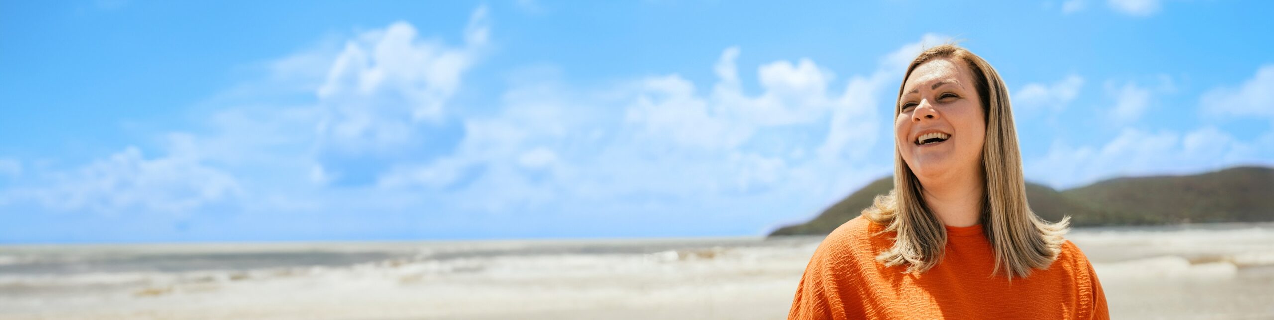 A woman laughing and looking to the side