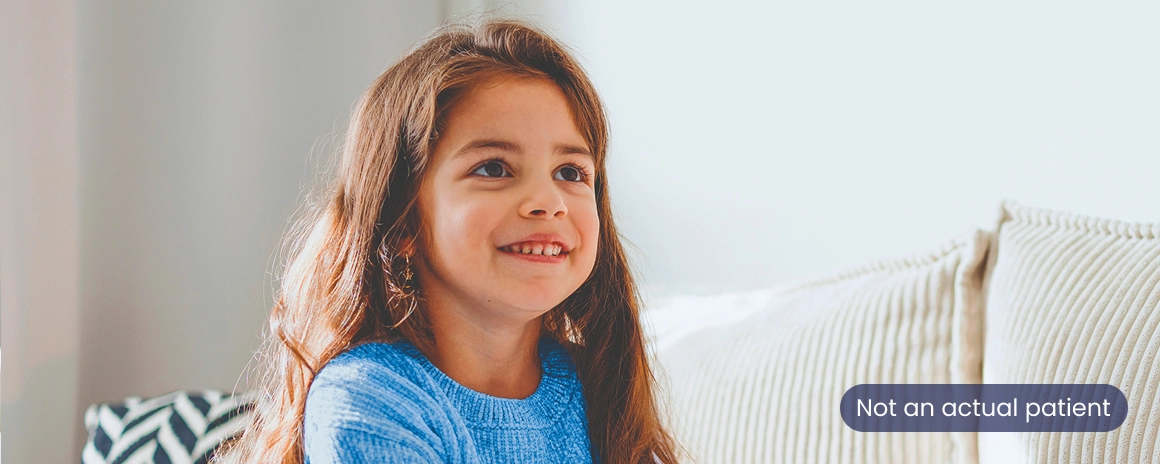 A young girl with long brown hair smiling